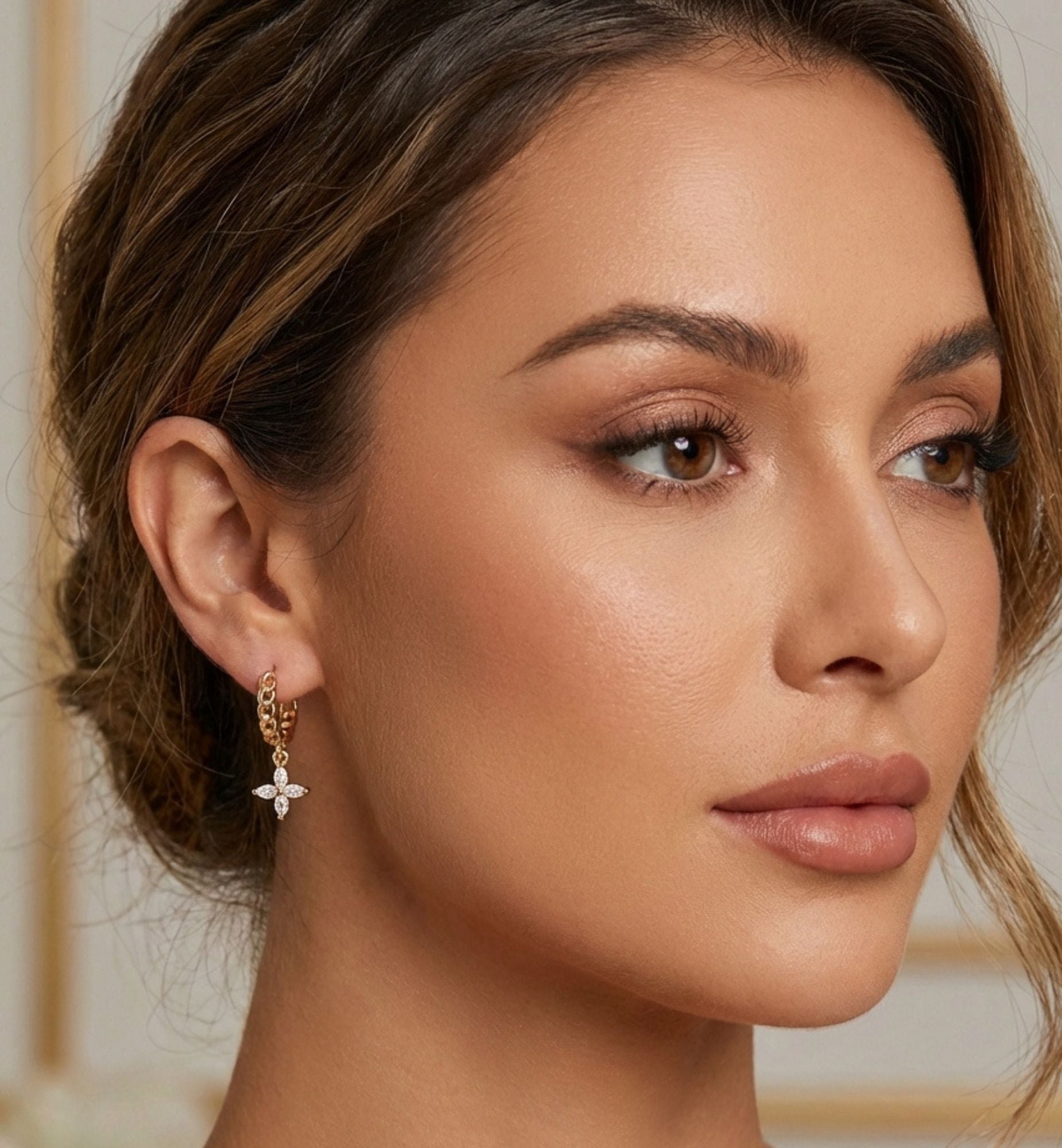 Close-up of a woman wearing gold earrings with a blurred background