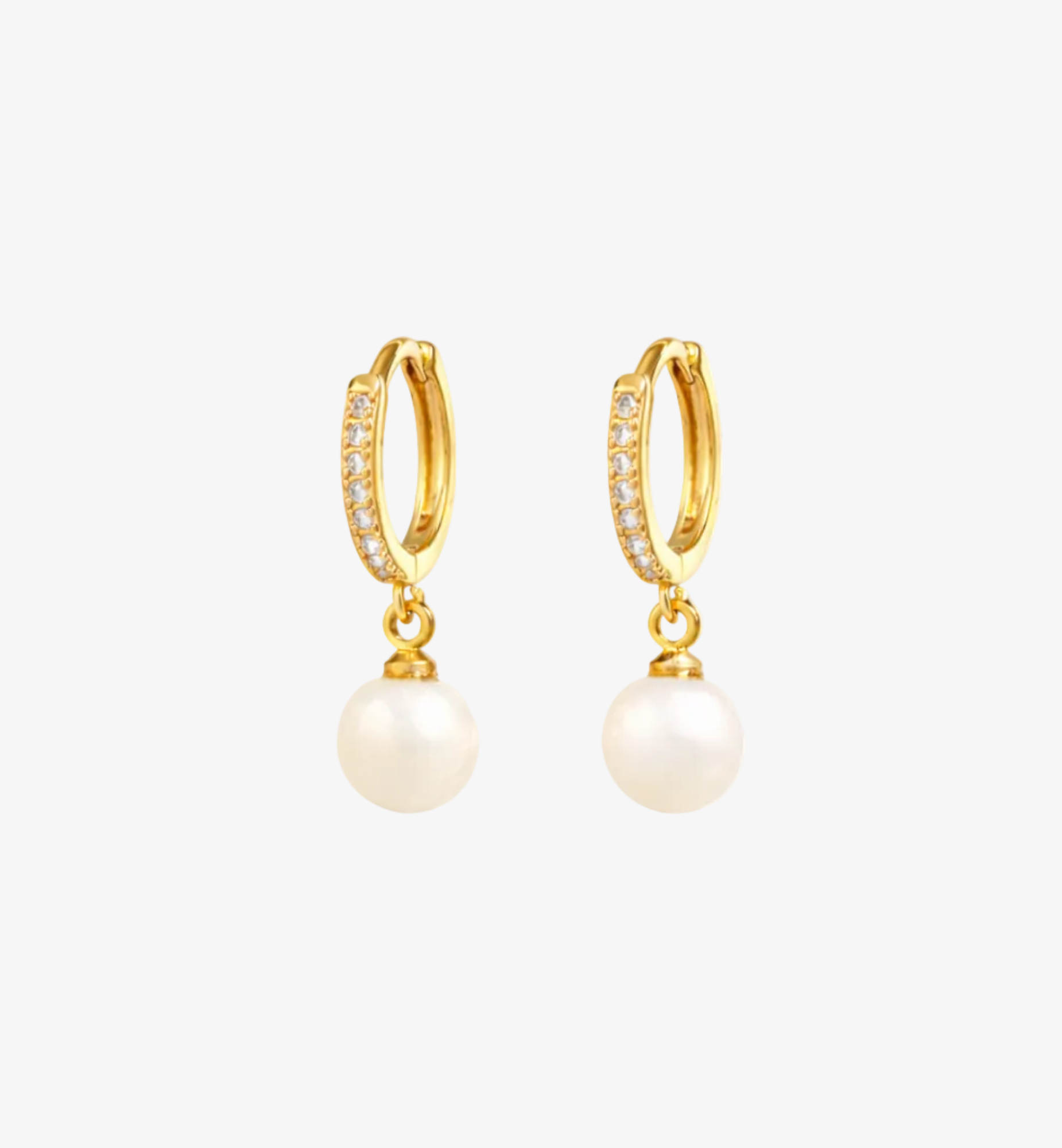 Gold hoop earrings with pearl drops on a white background
