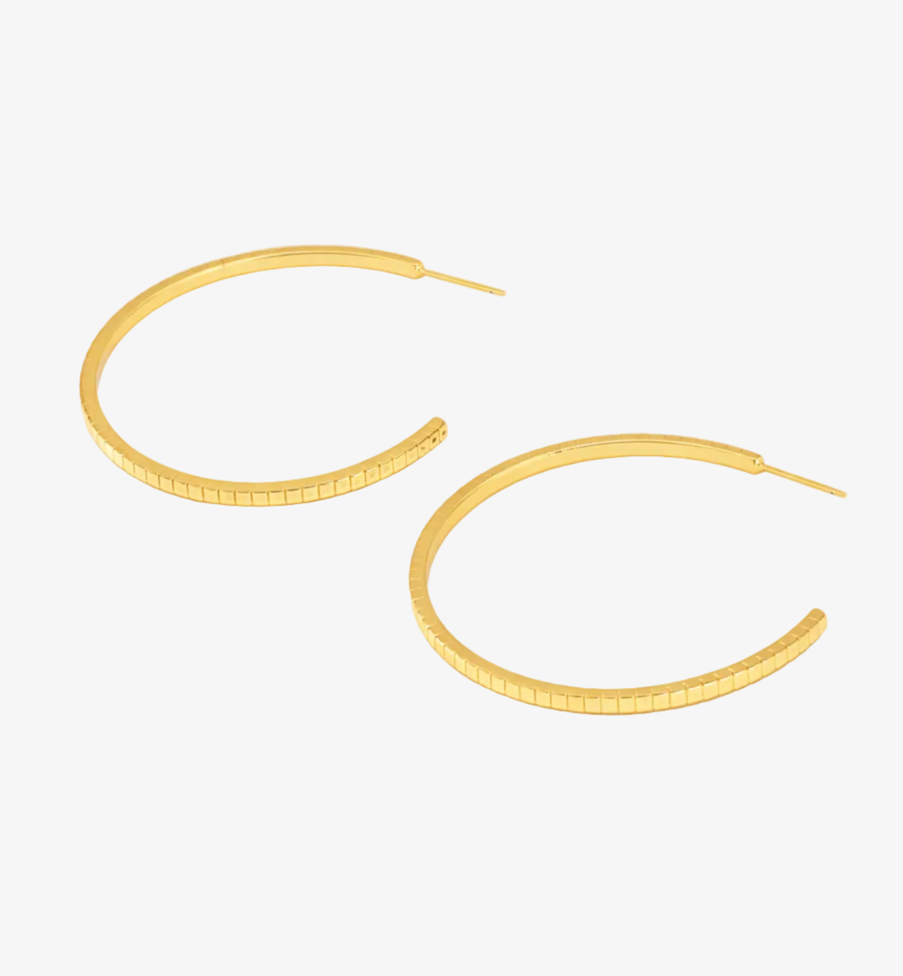 Gold hoop earrings on a light gray background