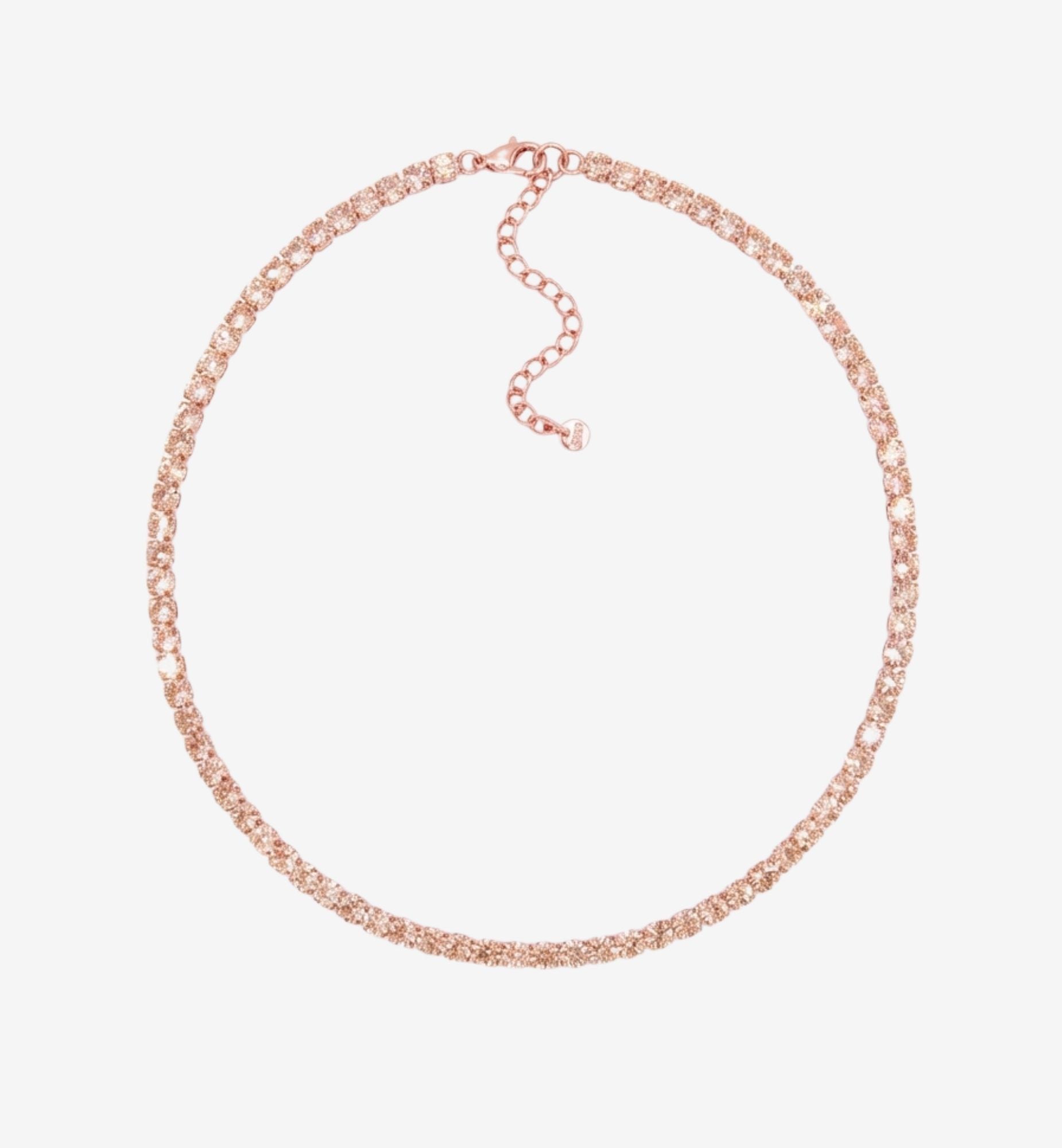 Rose gold necklace on a light pink background