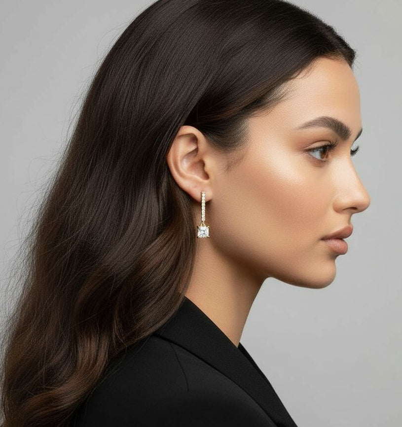 Woman wearing a diamond earring against a neutral background