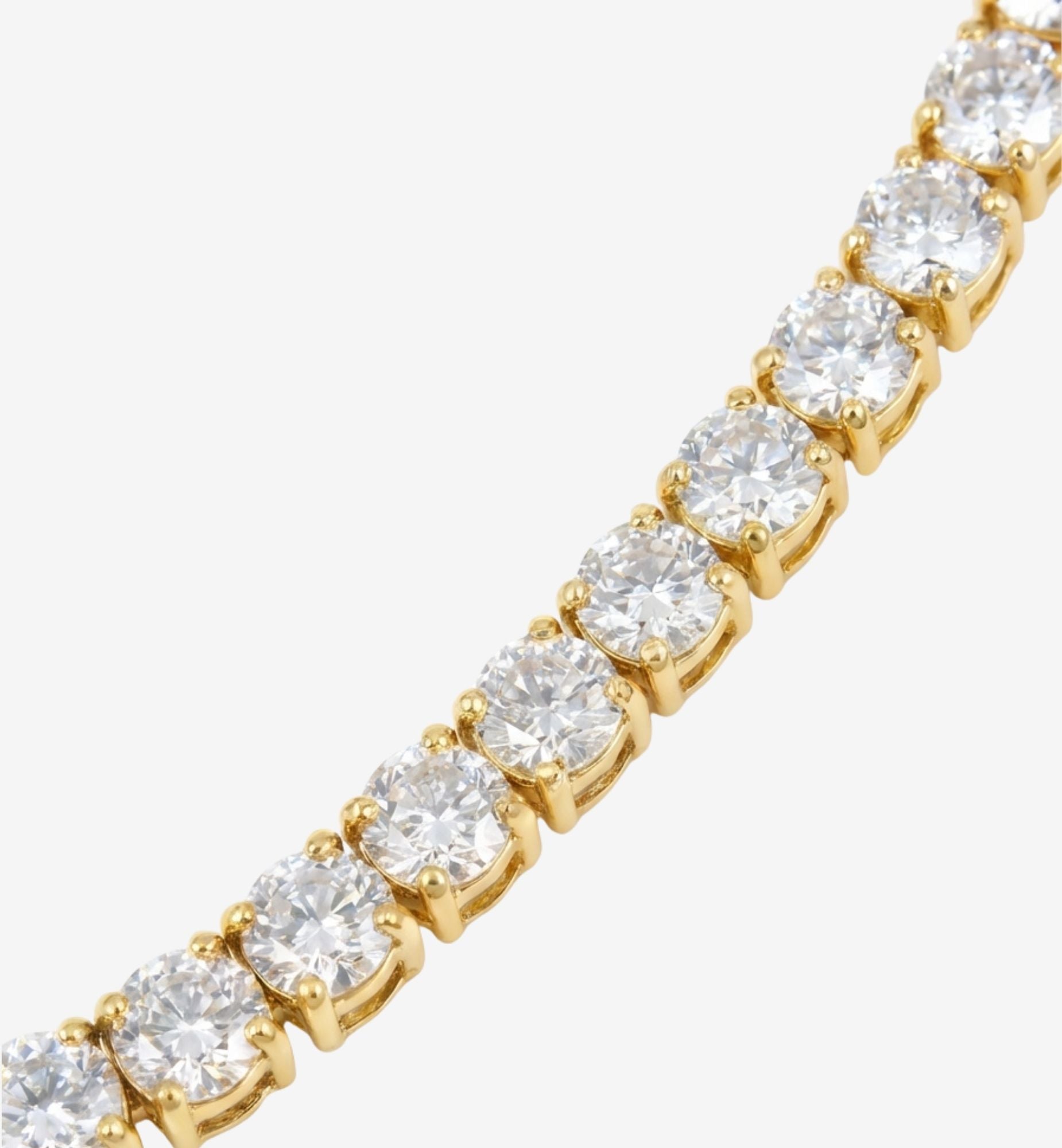 Gold bracelet with clear gemstones on a white background