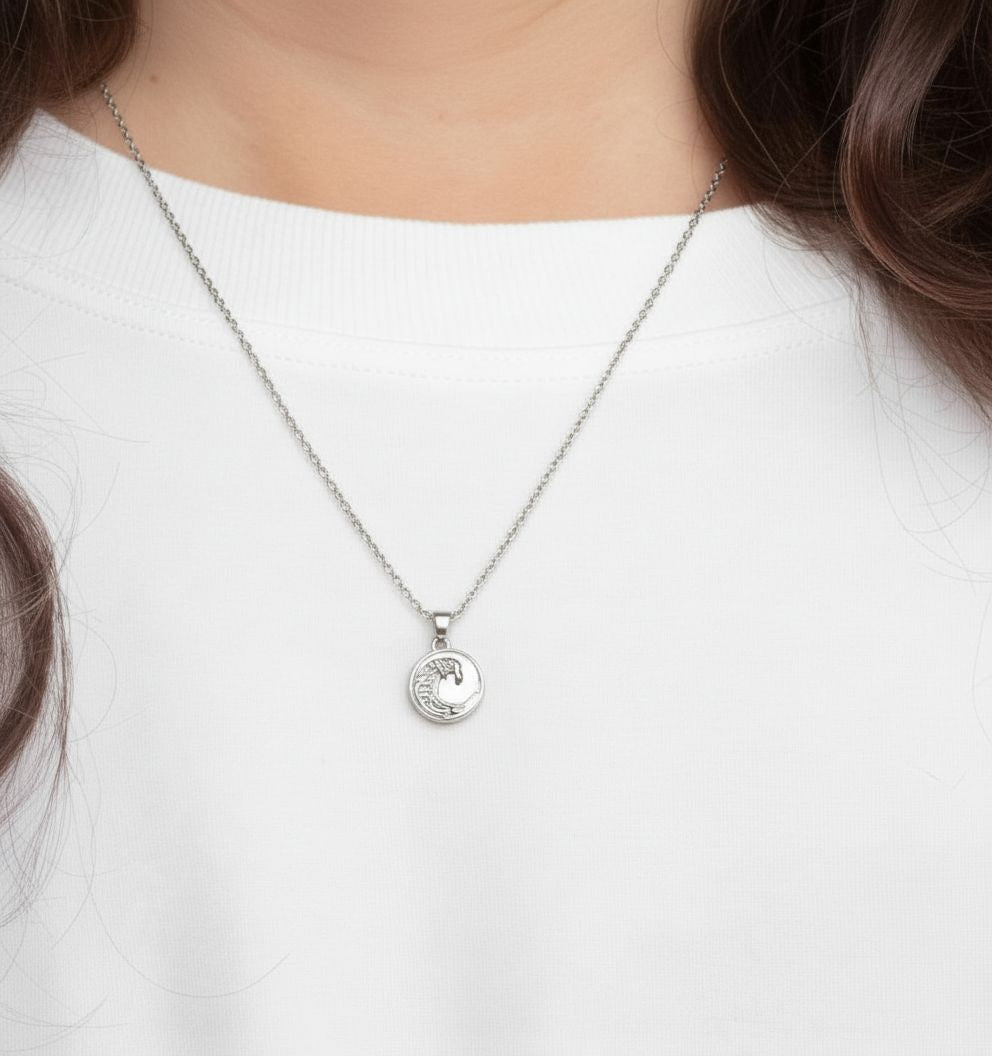 Silver necklace with a pendant worn by a person on a white background
